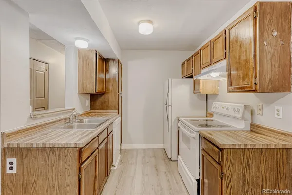 a kitchen that has a sink a stove and a microwave