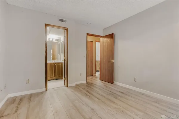 an empty room with wooden floor and closet
