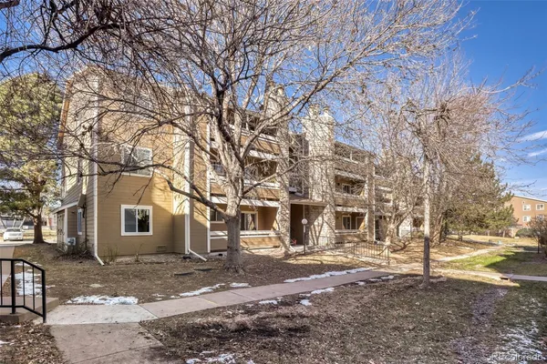 a view of a large white house with a large tree