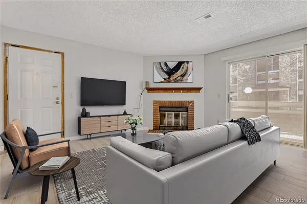 a living room with furniture a flat screen tv and a fireplace