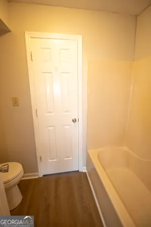 a bathroom with a granite countertop bathtub and toilet