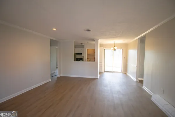 a view of a big room with wooden floor and windows