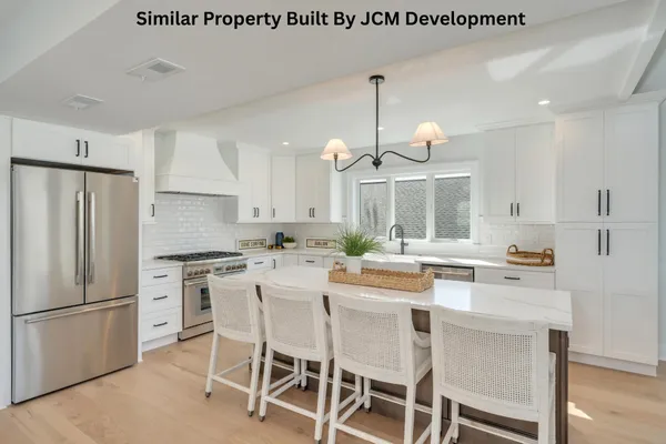 a kitchen with a dining table chairs stainless steel appliances and cabinets