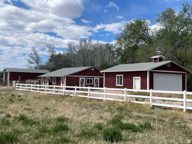 438 East Main Street Elsinore, UT 84724 - Photo 11 of 43 Red-painted outbuildings with white trim and a white fence line