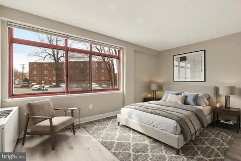 a bedroom with a bed and a large window