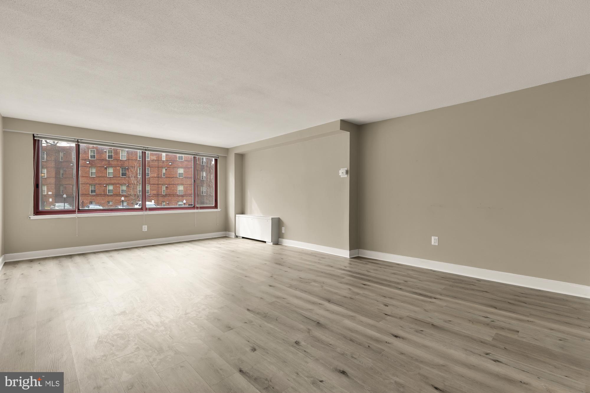 1220 Blair Mill Road, Unit 101 Silver Spring, MD 20910 - Photo 3 of 26 a view of an empty room with wooden floor and a window