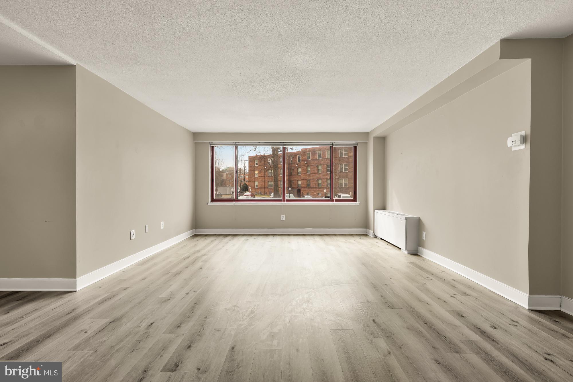 1220 Blair Mill Road, Unit 101 Silver Spring, MD 20910 - Photo 6 of 26 wooden floor in an empty room with a window