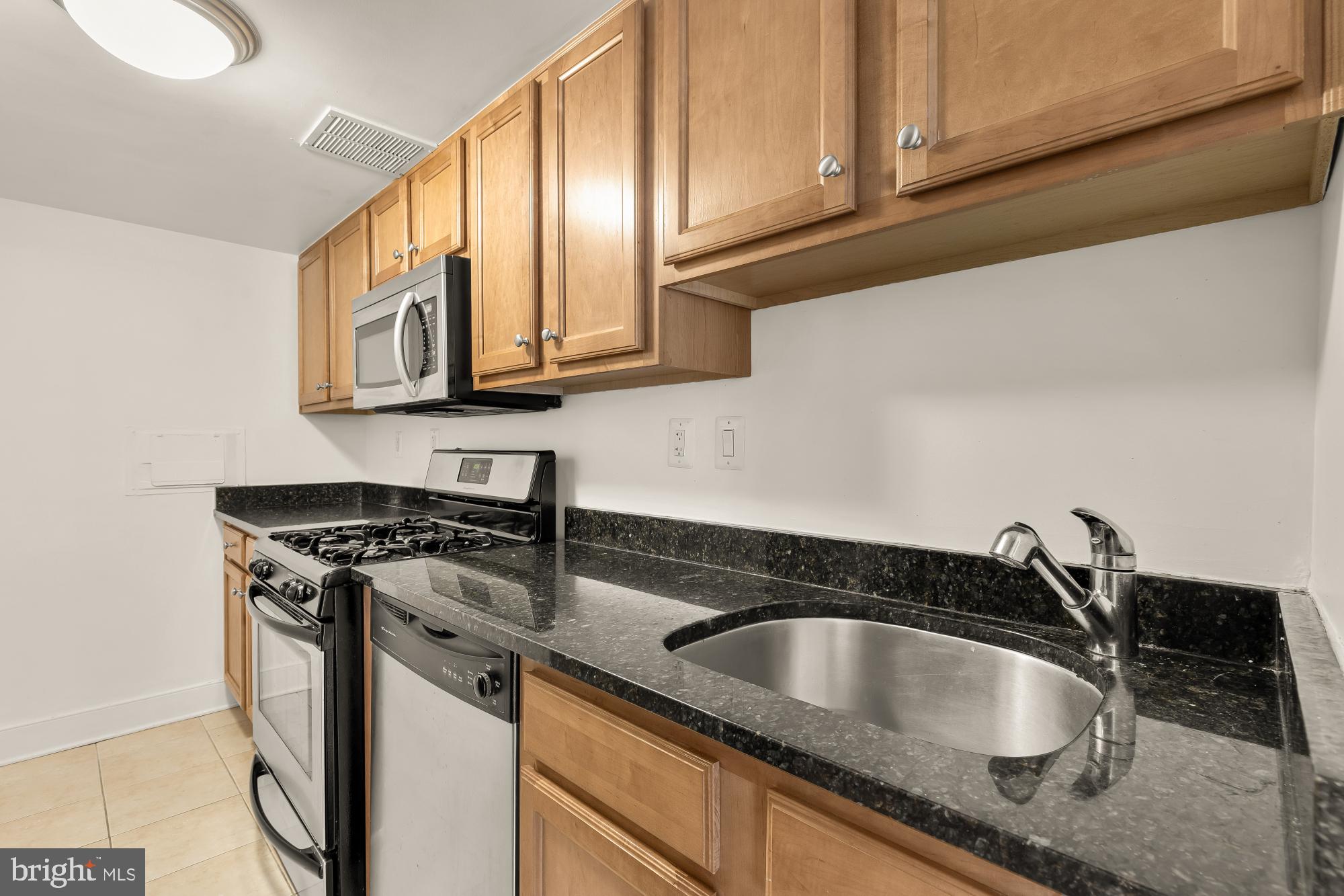 1220 Blair Mill Road, Unit 101 Silver Spring, MD 20910 - Photo 10 of 26 a kitchen with granite countertop a sink a stove and cabinets