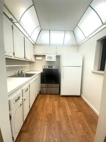 a kitchen with a sink a refrigerator and cabinets