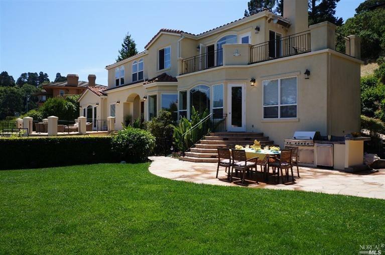 a front view of a house with patio and a garden