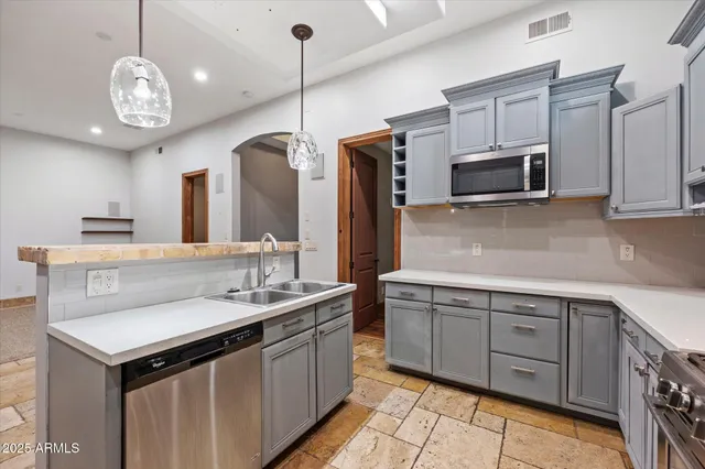a kitchen with stainless steel appliances granite countertop a refrigerator and a stove top oven
