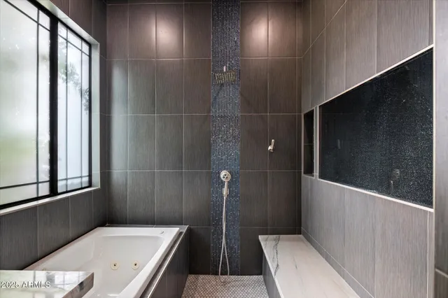 a bathroom with a tub sink and mirror