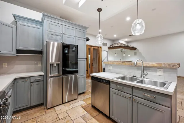 a kitchen that has a sink cabinets and stainless steel appliances