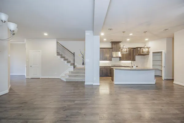 a view of kitchen with kitchen island stainless steel appliances refrigerator sink and cabinets