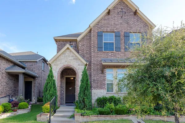 a view of a house with garden and large tree