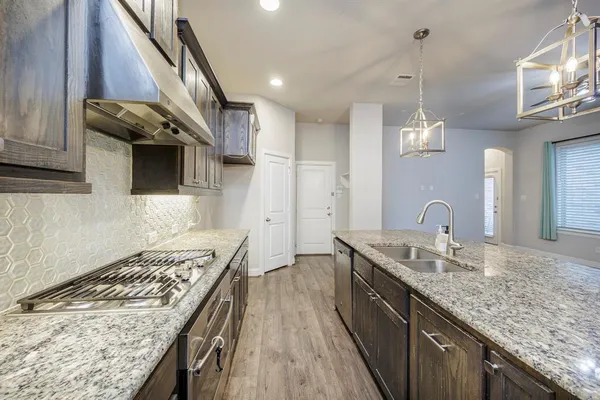 a kitchen with stainless steel appliances granite countertop a sink stove and cabinets