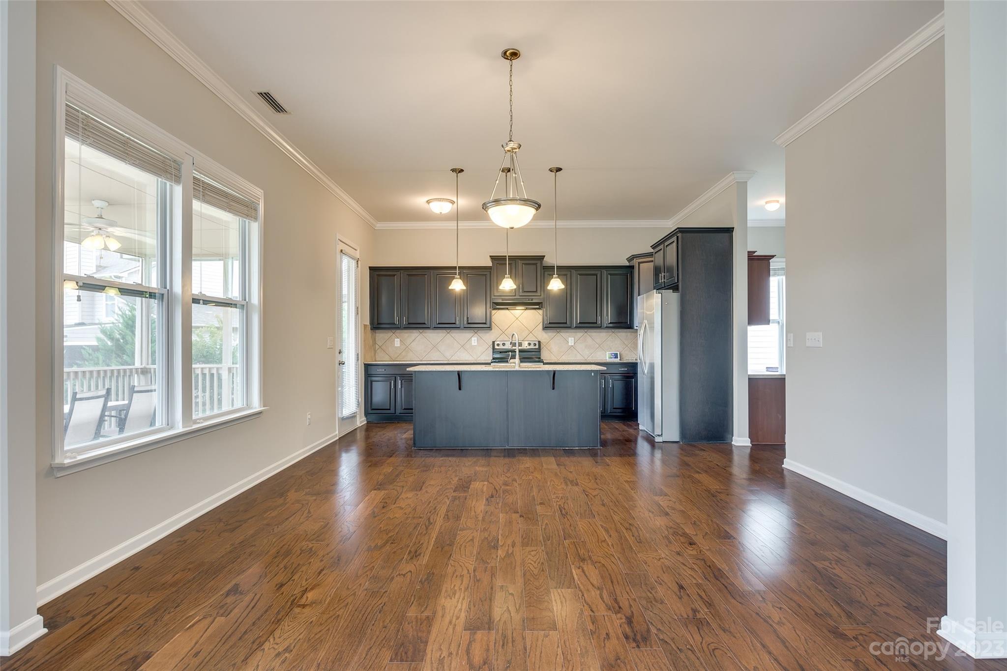 4025 Orchid Way Tega Cay, SC 29708 - Photo 12 of 44 a large kitchen with stainless steel appliances granite countertop a sink a window and wooden floor