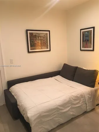 a bedroom with a bed and painting on the wall