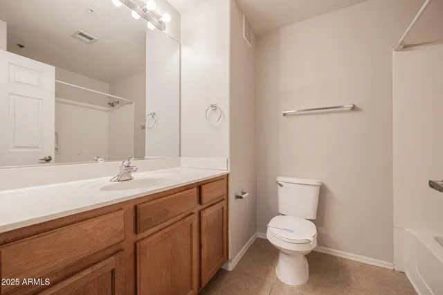 a bathroom with a toilet a sink a mirror and vanity