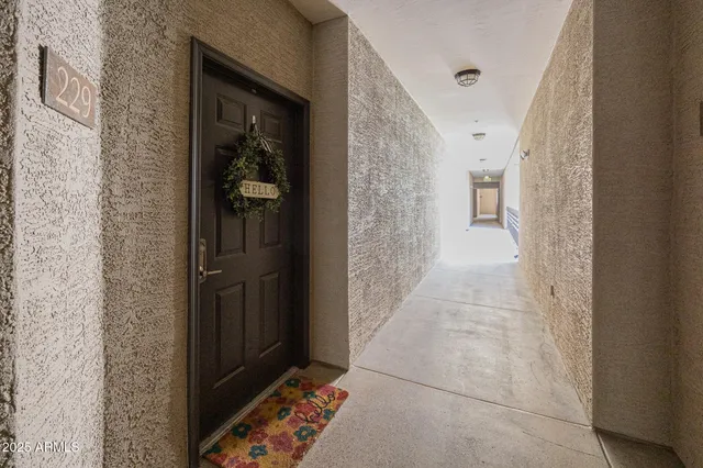 a view of a hallway with wooden floor and a bathroom