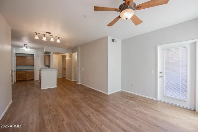 a view of a kitchen with wooden floor and a kitchen space with a sink