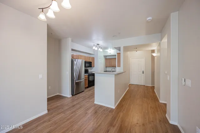 a view of a kitchen with refrigerator and wooden floor