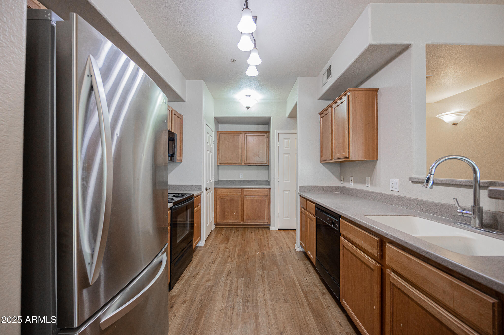 435 West Rio Salado Parkway, Unit 229 Tempe, AZ 85281 - Photo 10 of 26 a kitchen with stainless steel appliances granite countertop a refrigerator a sink dishwasher a stove and white countertops with wooden floor