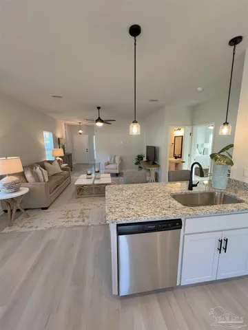 a large kitchen with stainless steel appliances granite countertop a stove a sink dishwasher with a wooden floor