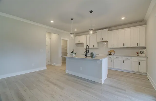 a open kitchen with white cabinets white stainless steel appliances and view living room