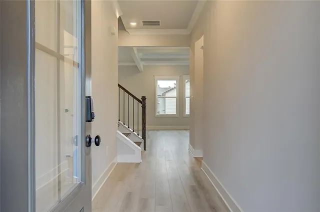 a view of a hallway with wooden floor and staircase
