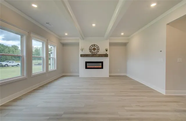 a view of an empty room with a window and a kitchen