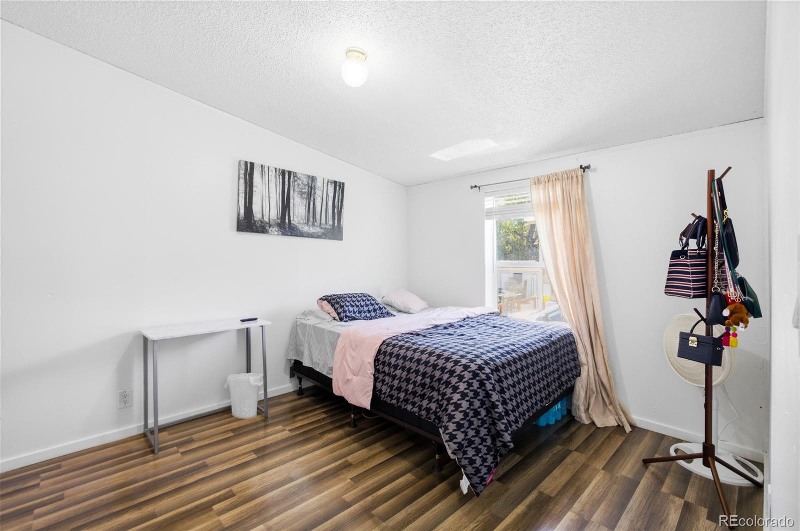 1724 Clark Street Aurora, CO 80011 - Photo 14 of 19 a bedroom with a bed and wooden floor