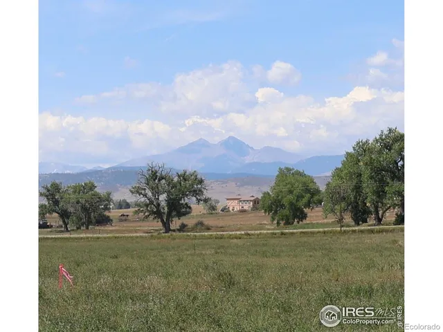 a view of a green field with wooden fence