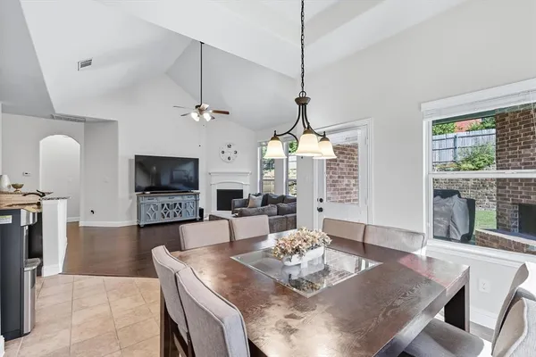 a living room with furniture a flat screen tv and a chandelier