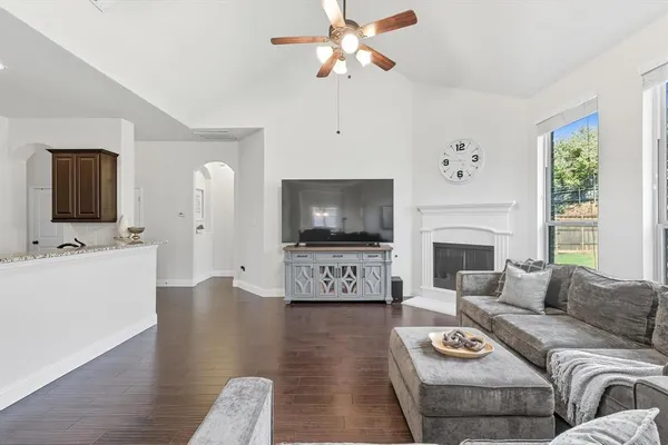 a living room with furniture a flat screen tv and a fireplace
