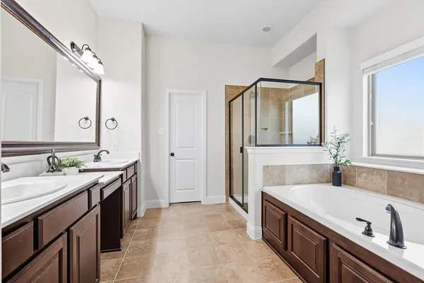 a spacious bathroom with a granite countertop sink mirror and bathtub