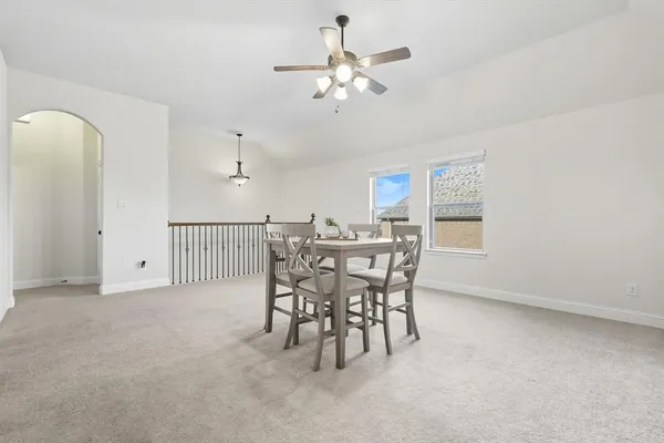 a view of a dining room with furniture and a chandelier fan