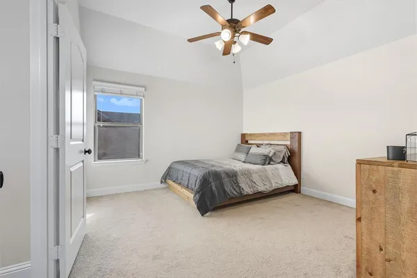 a spacious bedroom with a bed and a chandelier