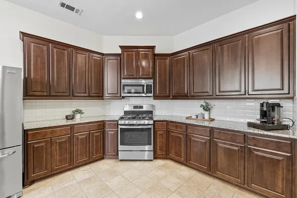 a kitchen with stainless steel appliances granite countertop a sink dishwasher stove and cabinets with wooden floor