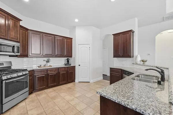 a kitchen with stainless steel appliances granite countertop a stove sink and cabinets