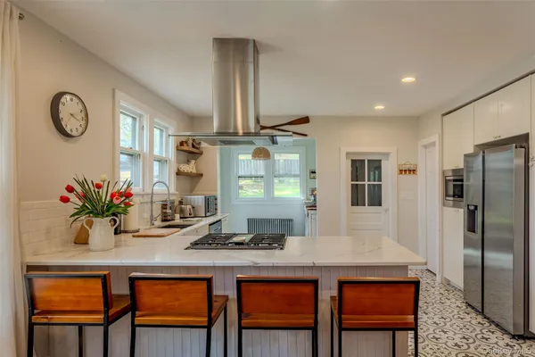 a kitchen with stainless steel appliances granite countertop a kitchen island a stove a table and chairs in it