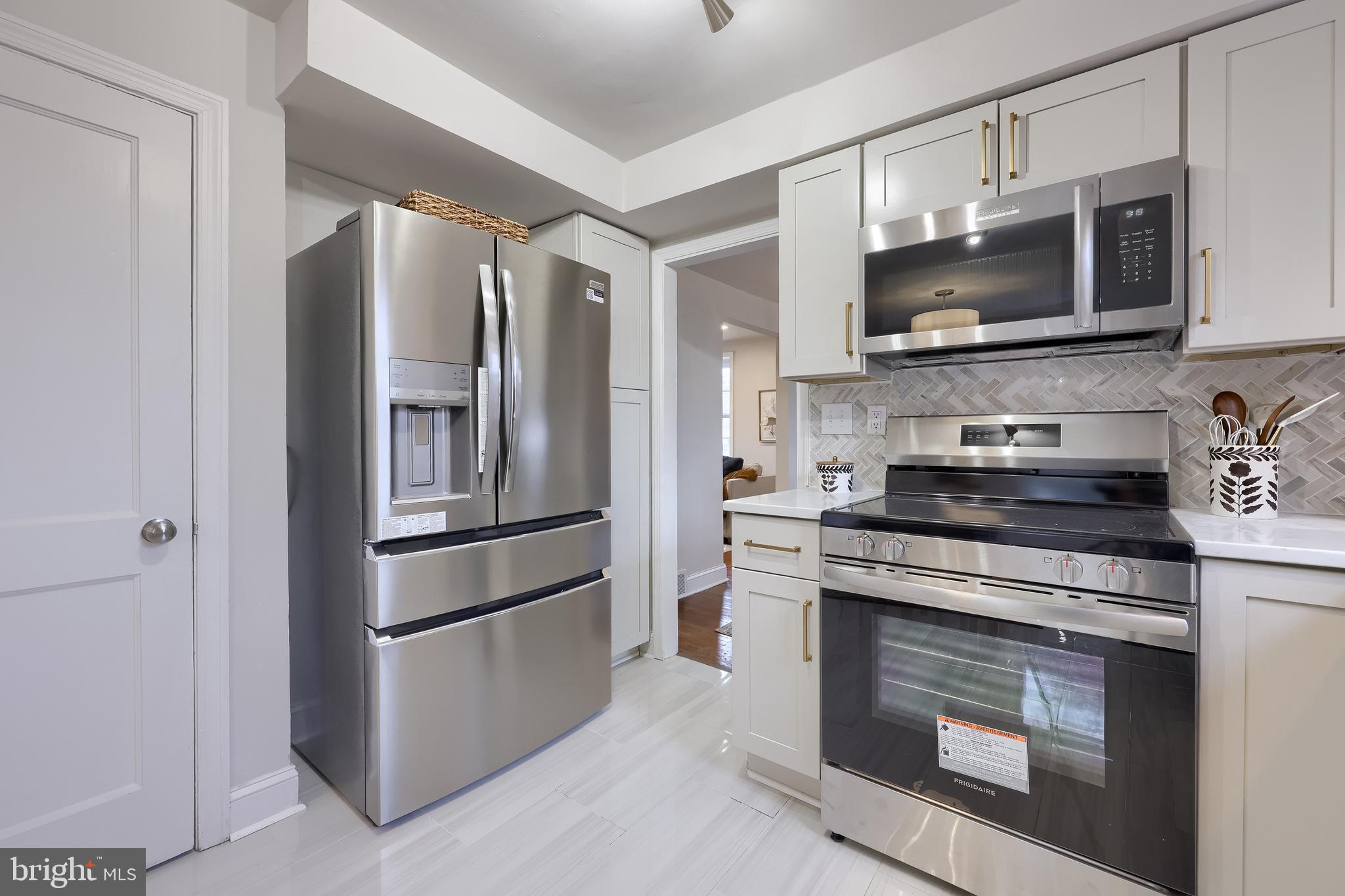 31 Wayfield Road Springfield, PA 19064 - Photo 16 of 49 a kitchen with stainless steel appliances granite countertop a stove microwave and refrigerator