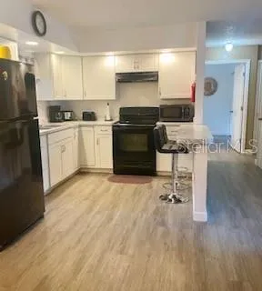 a kitchen with a refrigerator and a stove top oven