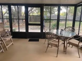 a dining room with furniture and large windows