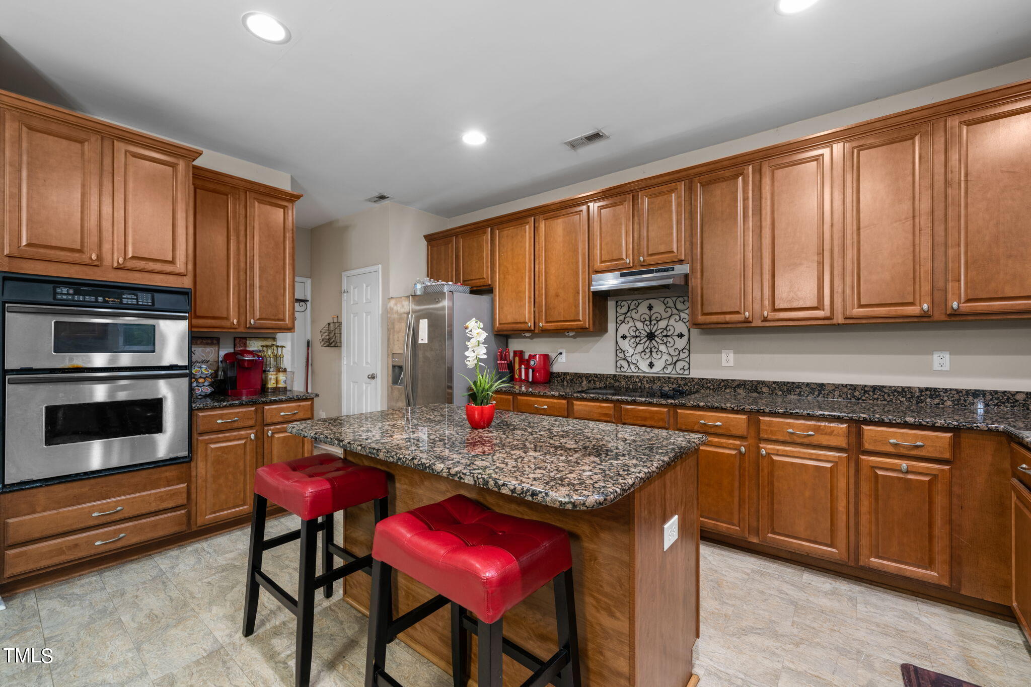 4040 Wester Road Raleigh, NC 27604 - Photo 4 of 35 a kitchen with kitchen island granite countertop wooden cabinets stainless steel appliances and a counter top space