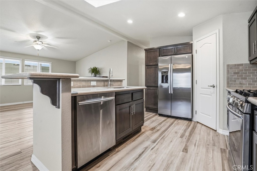 a kitchen with stainless steel appliances granite countertop a stove a refrigerator and a sink