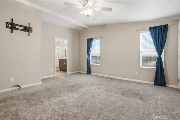an empty room with closet and a ceiling fan