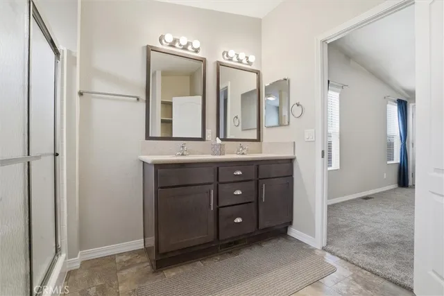 a bathroom with a granite countertop sink a mirror and a shower