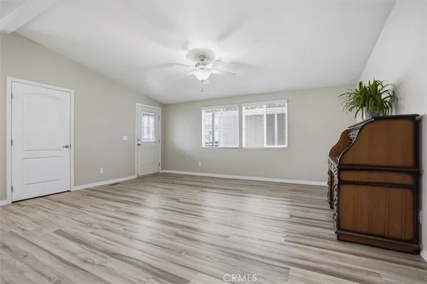 an empty room with wooden floor and window