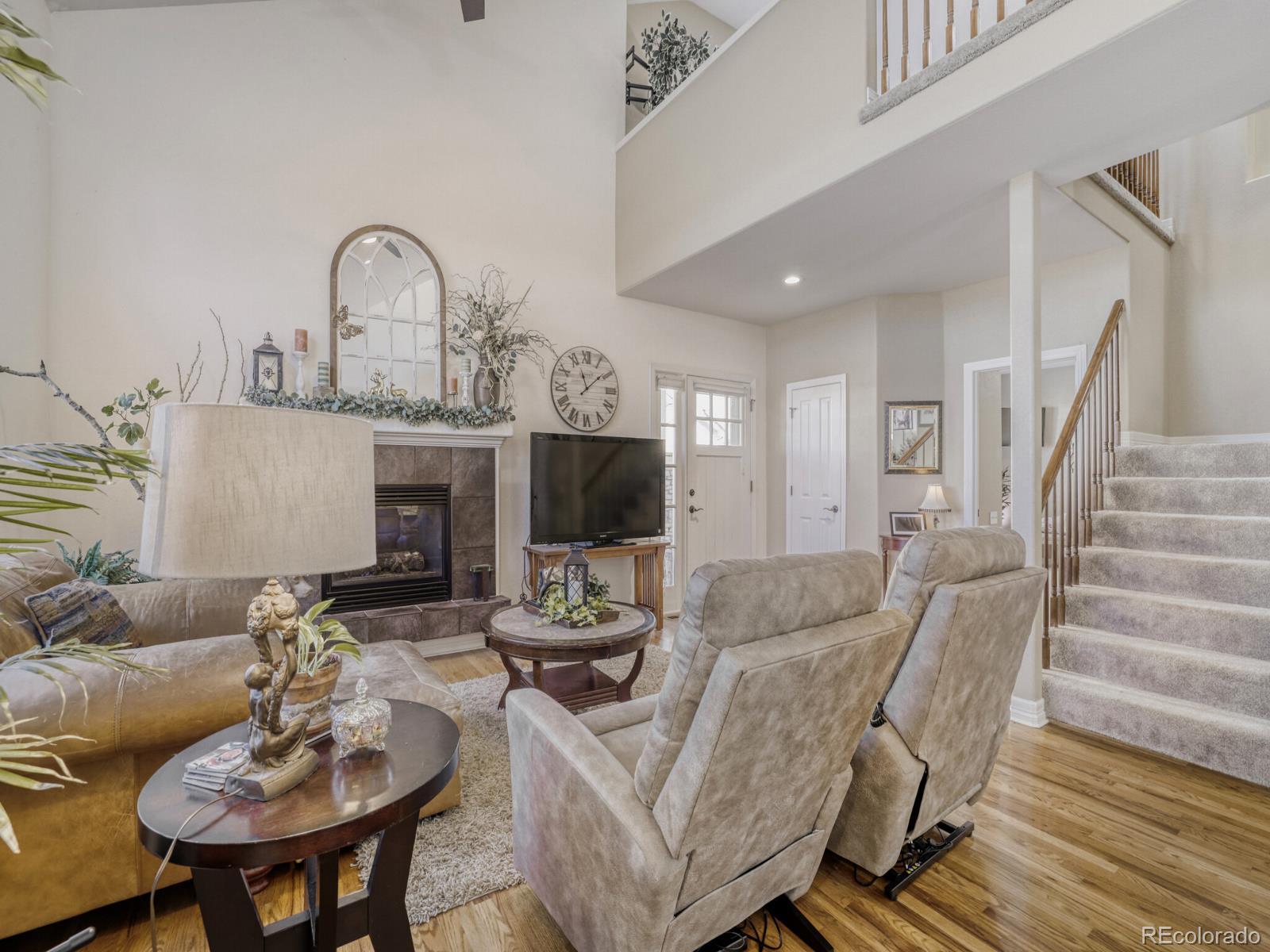 8893 Tappy Toorie Circle Highlands Ranch, CO 80129 - Photo 5 of 36 a living room with furniture kitchen view and a fireplace